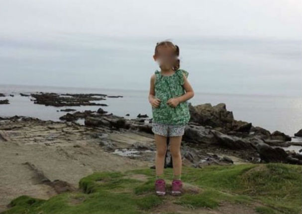 Mira la extraña figura que aparece detrás de una niña en una foto