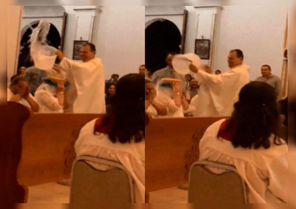 Sacerdote limpia de pecados a sus fieles con 'baldes' de agua bendita